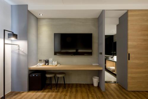 a room with a desk with a tv on the wall at Green Hotel in Magong