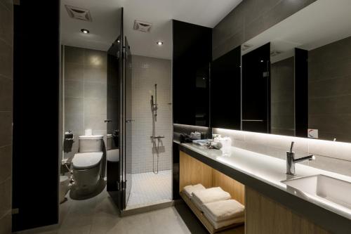 a bathroom with a toilet and a sink and a shower at Green Hotel in Magong