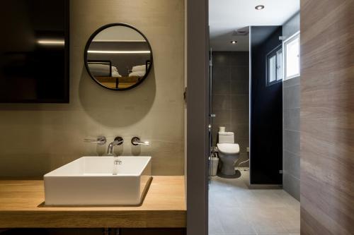 a bathroom with a white sink and a mirror at Green Hotel in Magong