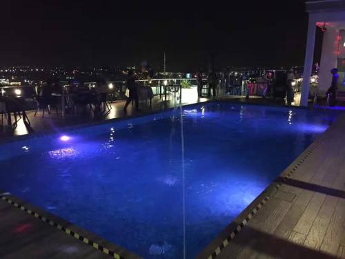 a large swimming pool with blue illumination at night at Amerin Hotel Johor Bahru in Johor Bahru