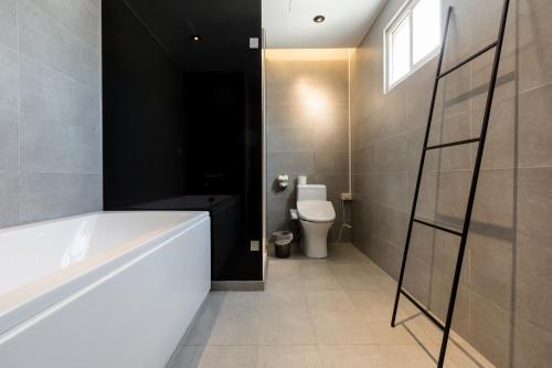 a bathroom with a white tub and a toilet at Green Hotel in Magong