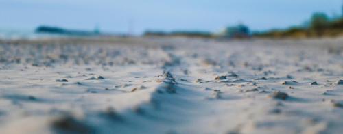 a close up of a beach with sand and rocks at Ośrodek Wypoczynkowy CHAMPION in Władysławowo