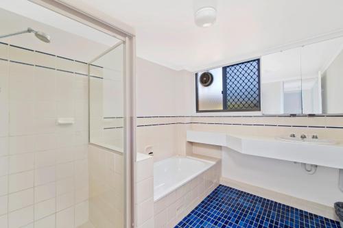 uma casa de banho com uma banheira, um lavatório e um chuveiro em Quarterdeck 7 7 Stewart Street em Port Macquarie