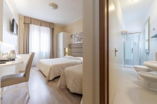 a bedroom with a bed and a bathroom with a sink at Hotel University in Bologna