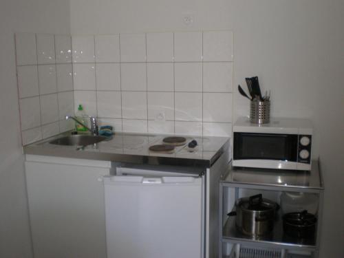 Kuchyň nebo kuchyňský kout v ubytování Appart Hotel de la Paix