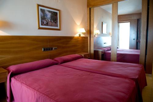 a hotel room with two beds and two lamps at Hotel La Maruxiña in La Alameda de la Sagra