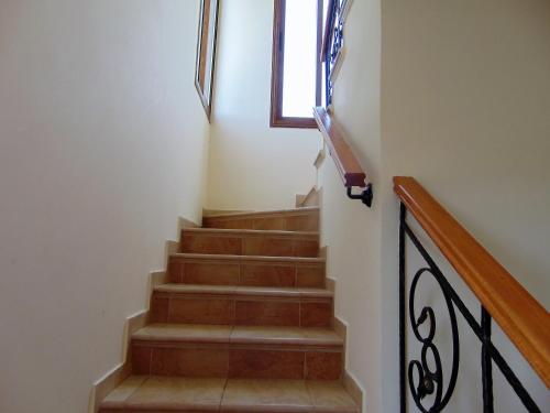 a stairway with a wooden rail and a window at Golden Valley Villa in Skoulli
