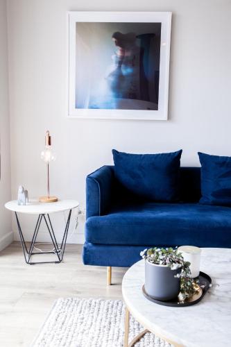 a blue couch in a living room with a table at Polperro Villas in Red Hill