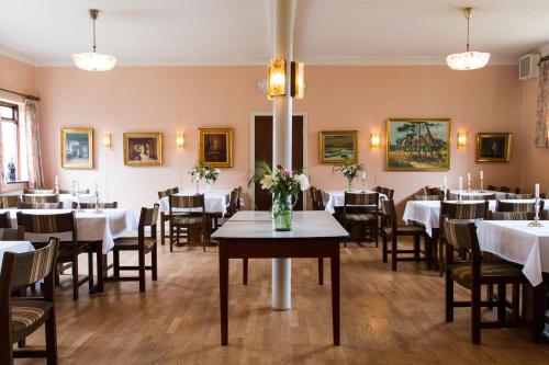 un comedor con mesas, sillas y velas en Hotel Inger, en Hulsig