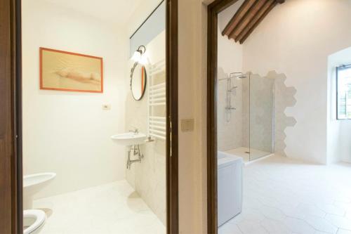 a bathroom with a toilet and a sink and a shower at Torre di Badia in Badia A Passignano