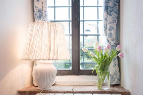 a lamp and a vase of flowers on a window sill at Torre di Badia in Badia A Passignano
