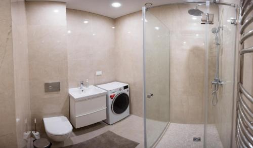 a bathroom with a washing machine and a washer at Loft on Owl Hill in Kaunas
