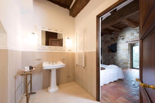 a bathroom with a sink and a bed in a room at Torre di Badia in Badia A Passignano
