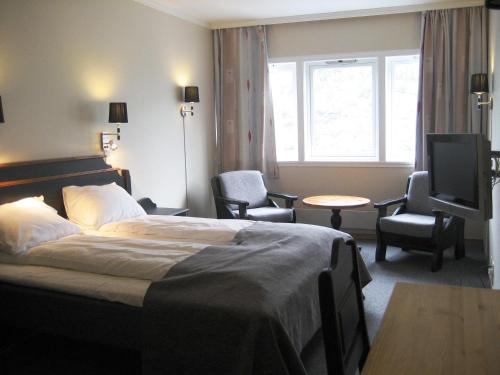 a hotel room with a bed and a tv at Motell Nor-Kro in Bromma