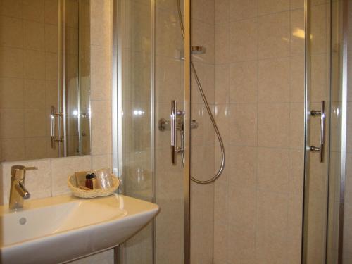 ein Bad mit einer Dusche und einem Waschbecken in der Unterkunft Motell Nor-Kro in Bromma