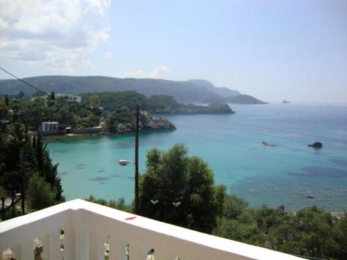 a view of the ocean from the balcony of a house at Anthimos Rooms in Paleokastritsa