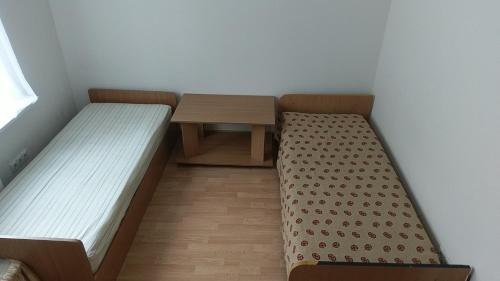 キーウにあるSviatoshyn aparthotelのベッド2台とテーブルが備わる小さな客室です。