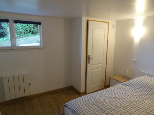 a bedroom with a bed and a window and a door at Gîte du Château d'Eau in Fécamp