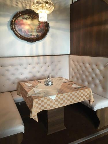 a table in a booth in a restaurant with a table sidx sidx sidx at B&B Villa Pipacs in Feketić