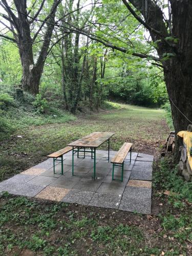a picnic table and two benches in a park at Casa Parentela in Ligornetto
