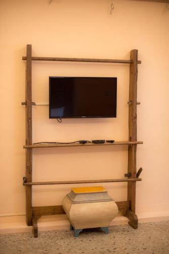 a flat screen tv on a wall with a shelf at Ripoll'es Homestay in Chishang