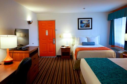 a hotel room with two beds and a red door at Howard Johnson by Wyndham Salinas in Salinas