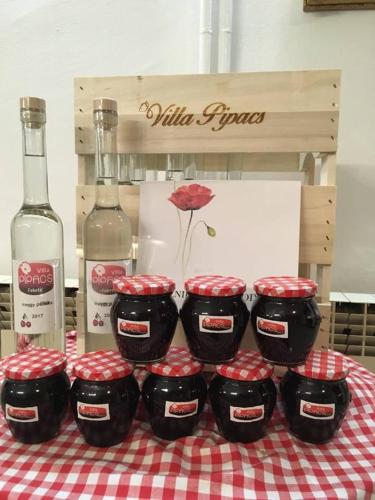 a group of four containers on a table with bottles of wine at B&B Villa Pipacs in Feketić