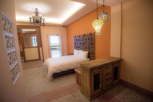 a bedroom with a bed and a table and a chandelier at Ripoll'es Homestay in Chishang