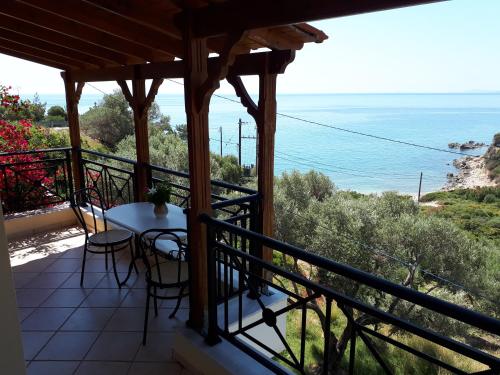 a balcony with a table and chairs and the ocean at Thalina Hotel in Marathokampos
