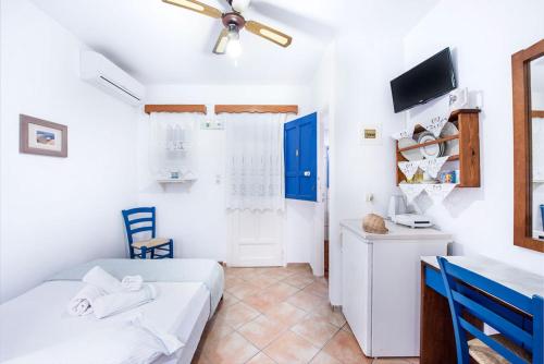 a small room with two beds and a desk at Erisimo in Aegiali