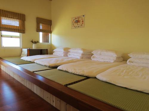 a bunch of beds lined up in a room at Mooning the Hill in Manzhou