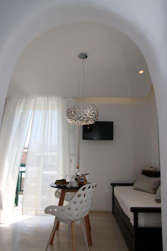 a room with a table and a bed and a chandelier at Spiros in Naxos Chora