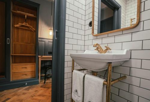 een badkamer met een wastafel en een spiegel bij Langley Hotel Gustavia in Chamonix-Mont-Blanc