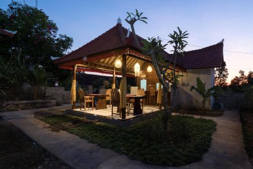a wooden gazebo with a table and chairs at Gatri Hut in Nusa Lembongan