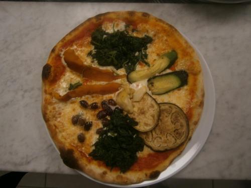 a pizza sitting on a plate on a table at Camping Klaus in Cavallino-Treporti