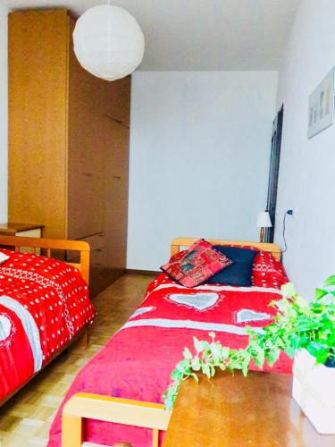 a bedroom with a bed with a red blanket at Casa Vacanze Santa Perpetua in Tirano