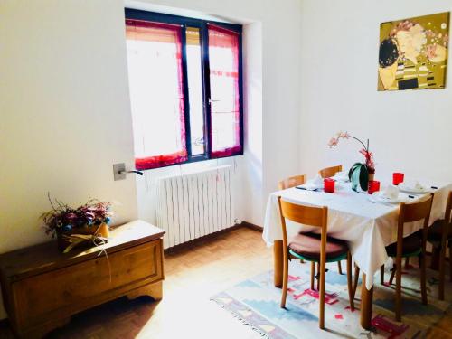 a dining room with a table and chairs and a window at Casa Vacanze Santa Perpetua in Tirano