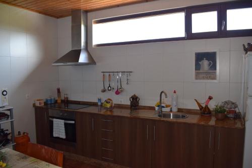 a kitchen with a counter and a sink and a window at Pensión Albergue Los Caminantes in Ribadiso