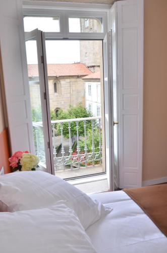 a bedroom with a bed and an open window at Hotel Montes in Santiago de Compostela