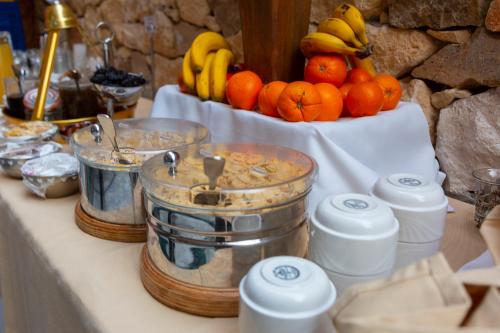 une table avec un bol d'oranges et de bananes dans l'établissement Olympus Mediterranean Boutique Hotel, à Litochoro