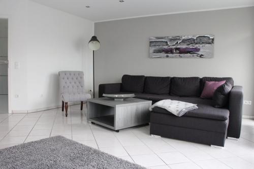 a living room with a black couch and a table at FeWo-Nordwalde in Nordwalde