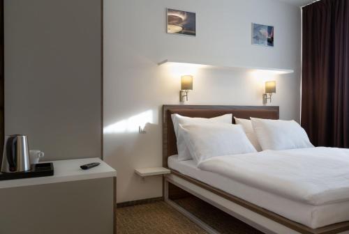 a hotel room with a white bed and white comforter at Skyhotel Prague in Prague