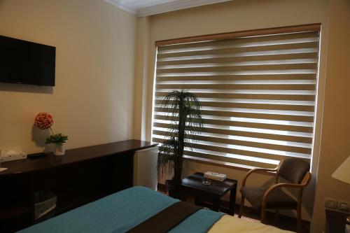 a bedroom with a bed and a window with a window blind at Rozana Hotel in Amman