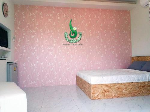 a room with two beds and a pink wall at Heuan Na Khee in Udon Thani