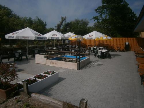 a patio with tables and chairs and umbrellas at Camping Klaus in Cavallino-Treporti