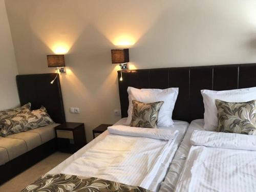 a hotel room with two beds and a couch at B&B Villa Pipacs in Feketić