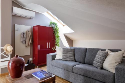 a living room with a couch and a red door at Vialeromadodici Rooms & Apartments in Lazise