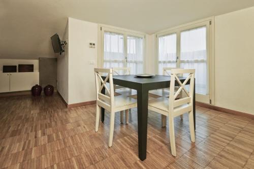 a dining room with a black table and two chairs at Vialeromadodici Rooms & Apartments in Lazise