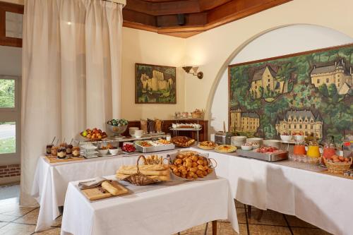 un buffet con dos mesas llenas de comida en Relais des Trois Châteaux Hôtel-Restaurant - Teritoria, en Cour-Cheverny