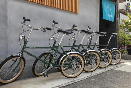 a row of bikes parked next to a wall at ORI stay and living in Kyoto